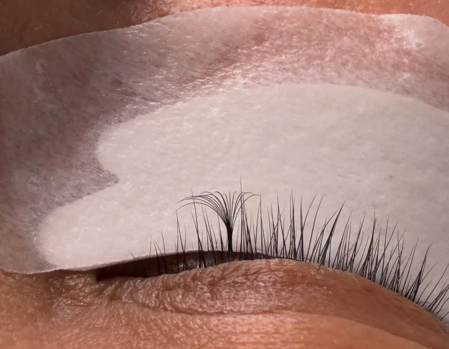 Lash extensions being isolated one at a time over under-eye pads